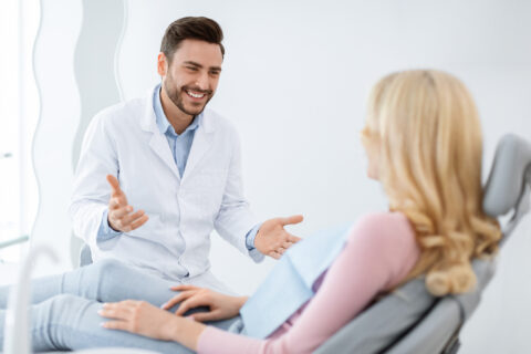 Dentist having friendly conversation with his patient regarding her dental health,GA