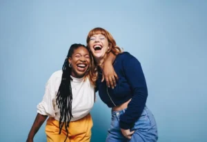 Two friends laughing and having a good time together in the studio